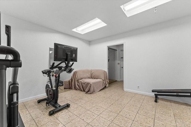 workout room with baseboards and tile patterned floors