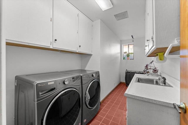 laundry area with washing machine and clothes dryer, cabinet space, a sink, dark tile patterned floors, and baseboards