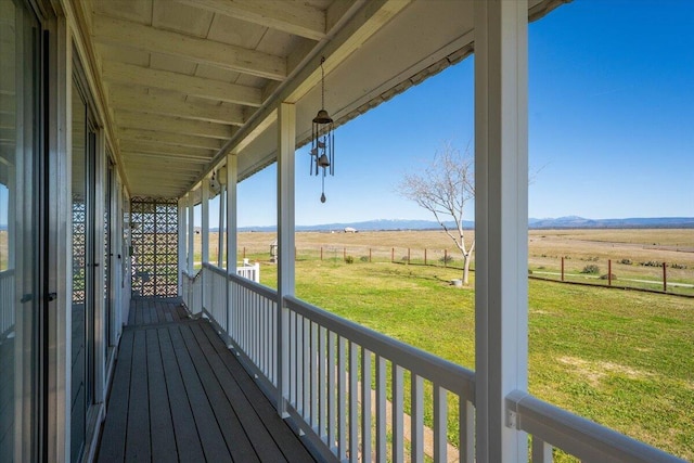 deck with a yard and a rural view