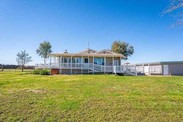 rear view of house featuring a yard, a chimney, and a wooden deck