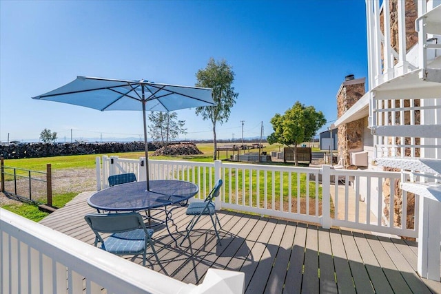 deck with outdoor dining space and a lawn