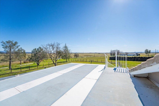 view of patio featuring a rural view and fence