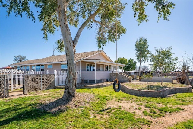 back of house featuring fence and a lawn