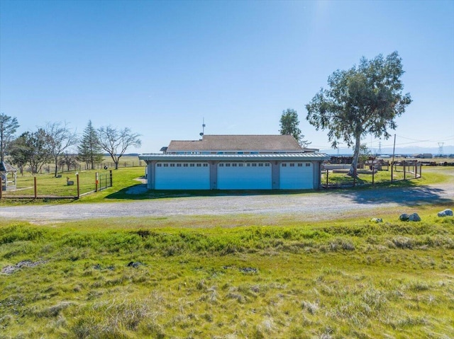 garage featuring driveway and fence