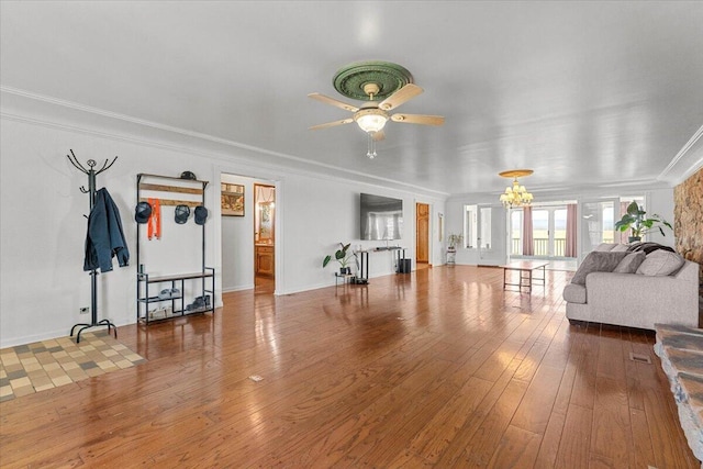 living room featuring crown molding, baseboards, hardwood / wood-style floors, and ceiling fan with notable chandelier