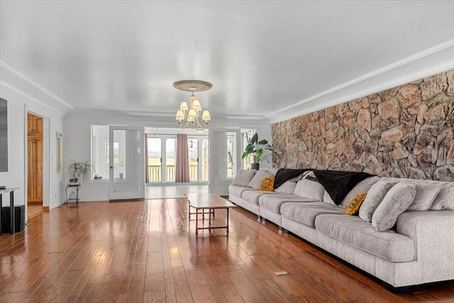 living area with a chandelier, hardwood / wood-style floors, and crown molding