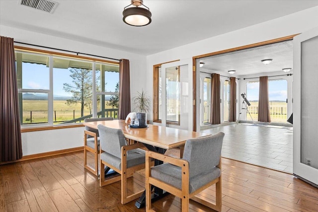 dining space featuring hardwood / wood-style flooring, visible vents, and a wealth of natural light