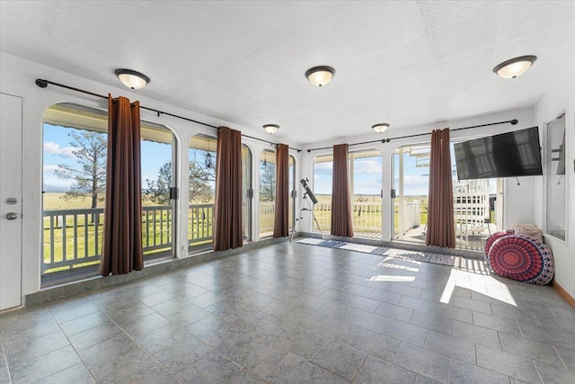 interior space with a textured ceiling and baseboards