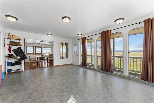 unfurnished living room featuring baseboards