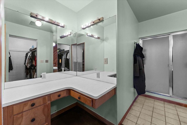 bathroom featuring an enclosed shower, baseboards, and tile patterned floors