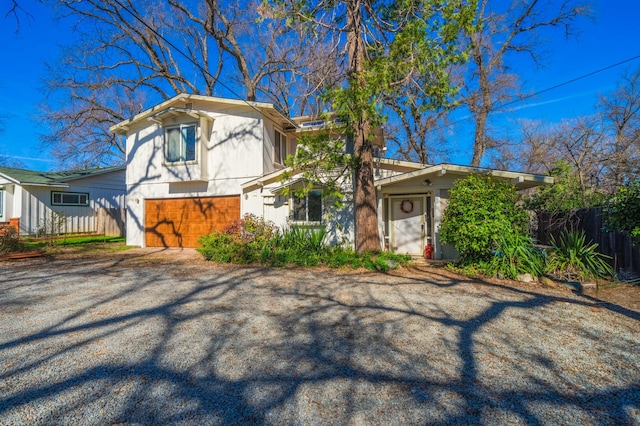 view of front of home featuring driveway and fence