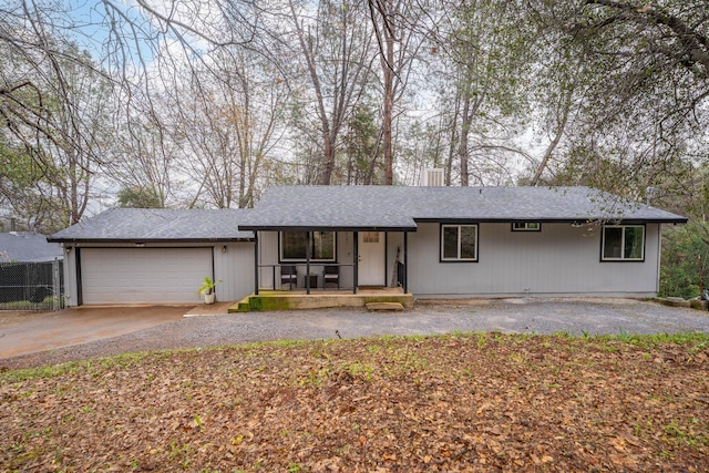 single story home featuring driveway, a garage, fence, and a porch