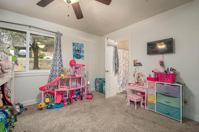 game room with carpet, a ceiling fan, and baseboards