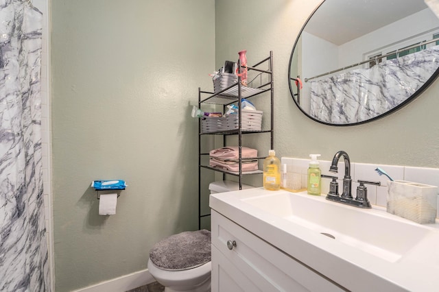 bathroom with a textured wall, vanity, toilet, and a shower with curtain