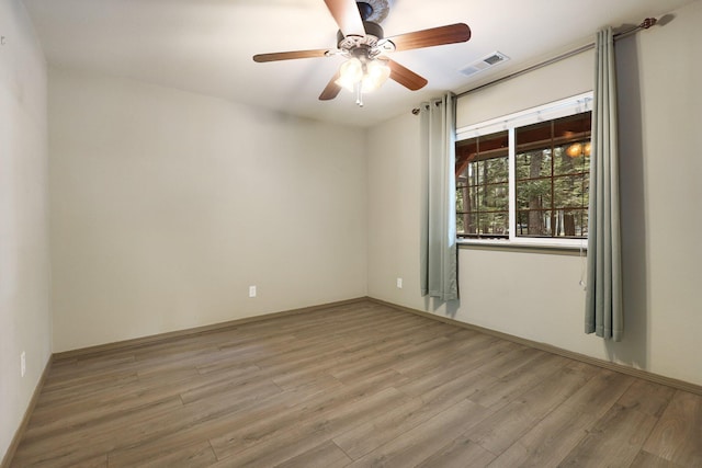 unfurnished room with light wood-type flooring, ceiling fan, and visible vents