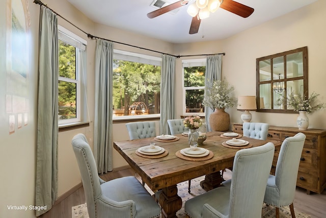 dining room with a wealth of natural light, visible vents, ceiling fan, and wood finished floors