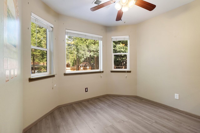 spare room with light wood-style floors, visible vents, baseboards, and a ceiling fan