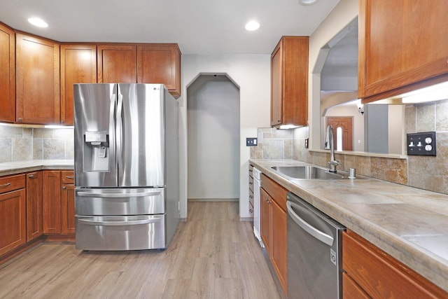 kitchen with light wood finished floors, light countertops, appliances with stainless steel finishes, and a sink