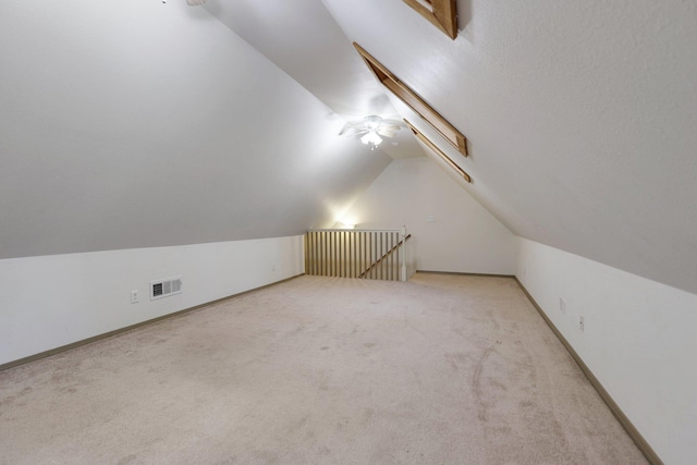 additional living space with lofted ceiling, baseboards, visible vents, and carpet flooring