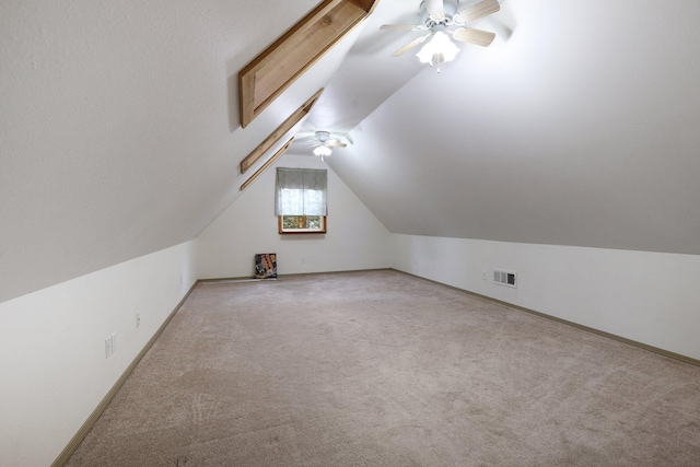 additional living space with lofted ceiling, carpet flooring, visible vents, and a ceiling fan