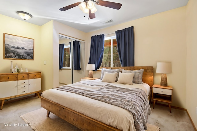 carpeted bedroom featuring a ceiling fan, visible vents, and baseboards