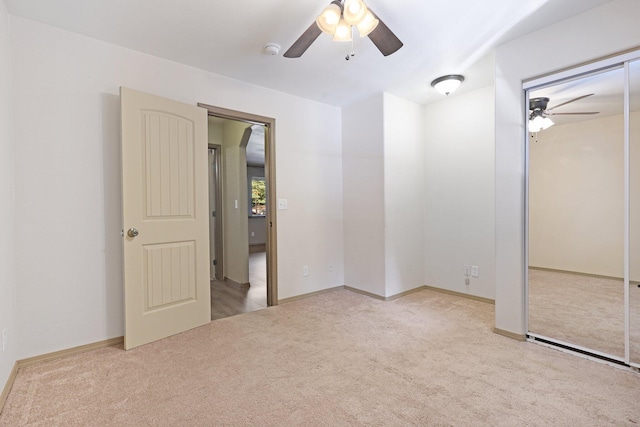 unfurnished bedroom with carpet floors, a closet, baseboards, and a ceiling fan