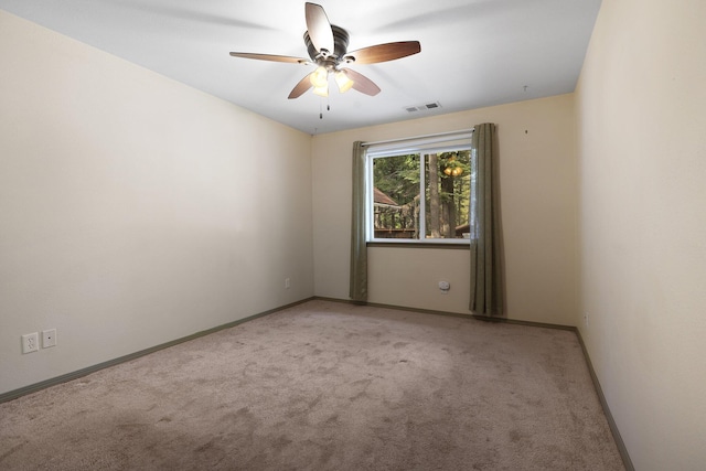 empty room featuring ceiling fan, carpet flooring, visible vents, and baseboards