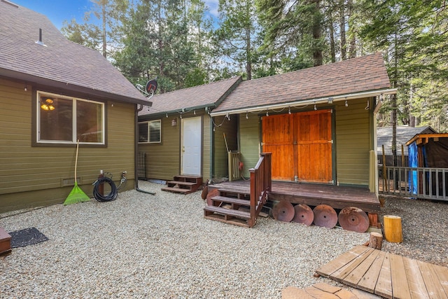 exterior space with a shingled roof and entry steps