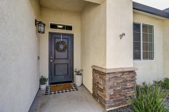 doorway to property featuring stucco siding