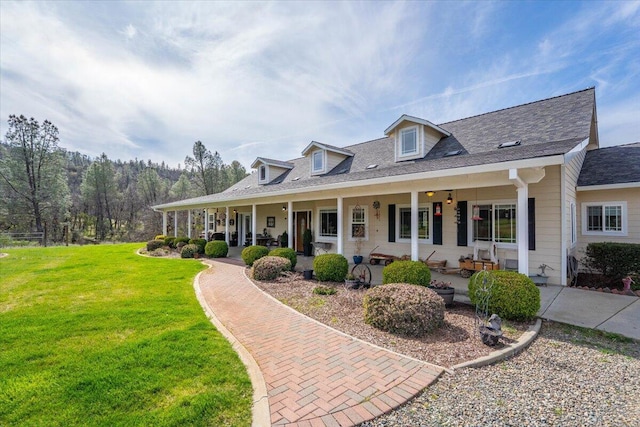 cape cod house featuring a front yard and covered porch