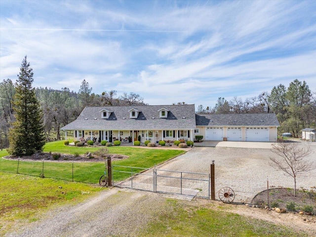 view of front of house with a fenced front yard, driveway, a front yard, and a gate