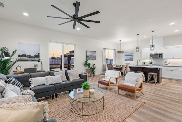 living room with light wood-style flooring, plenty of natural light, visible vents, and recessed lighting