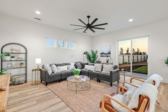 living room featuring light wood-style flooring, visible vents, ceiling fan, and recessed lighting