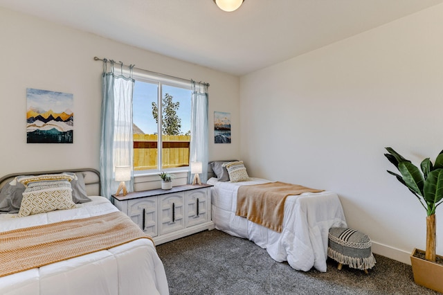 bedroom featuring dark colored carpet and baseboards