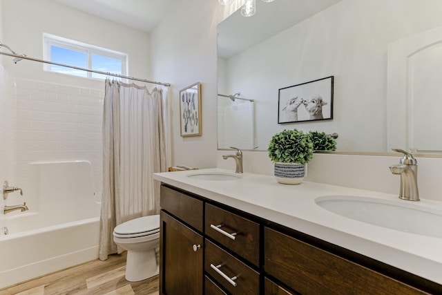 full bath featuring toilet, shower / bath combo, a sink, and wood finished floors