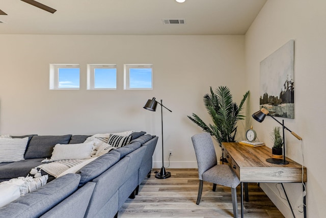 home office featuring a ceiling fan, visible vents, light wood-style flooring, and baseboards