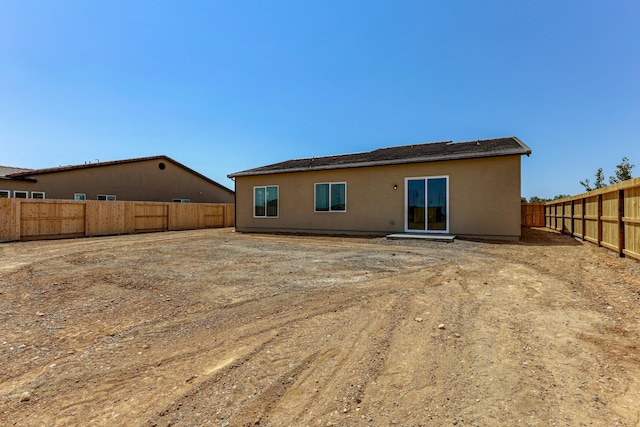 back of property featuring a fenced backyard and stucco siding