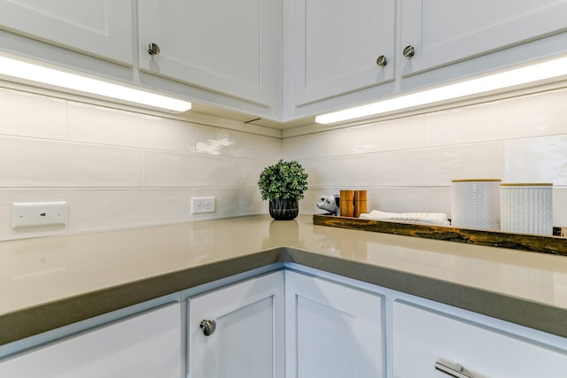 details featuring dark countertops, white cabinets, and decorative backsplash