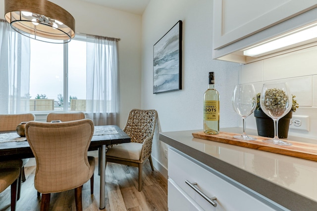 dining room featuring light wood-type flooring and baseboards