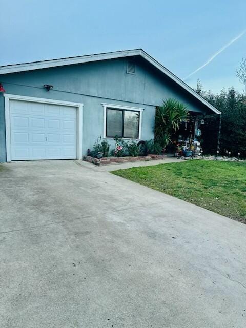 view of front of property featuring a front lawn, an attached garage, and driveway