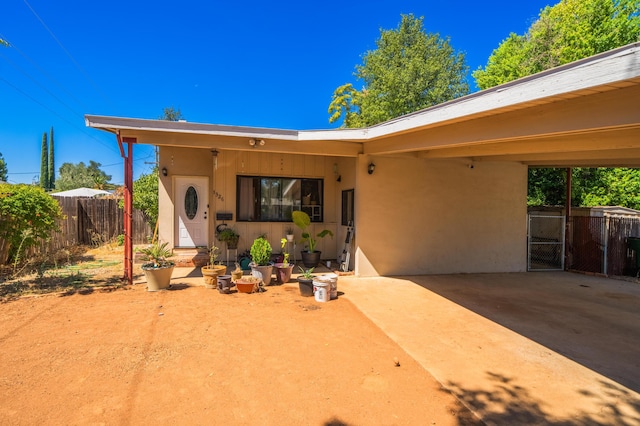 exterior space featuring a gate, fence, and stucco siding