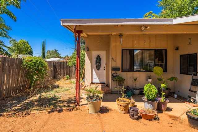 entrance to property featuring a patio area and fence