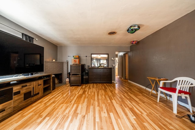 living area with light wood-type flooring, baseboards, and visible vents