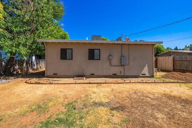 back of house with crawl space and fence