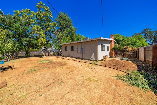 back of property with a fenced backyard and a chimney