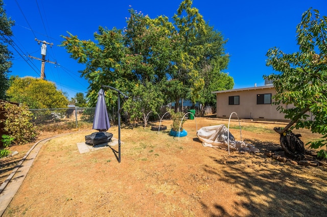 view of yard with fence and a fire pit