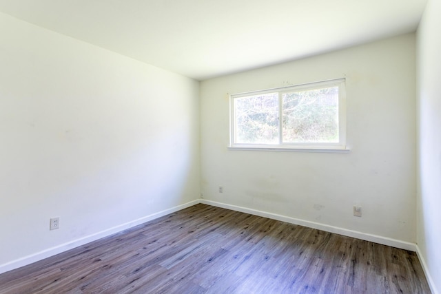 unfurnished room featuring baseboards and wood finished floors