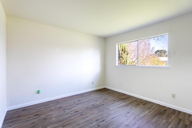 empty room with baseboards and wood finished floors