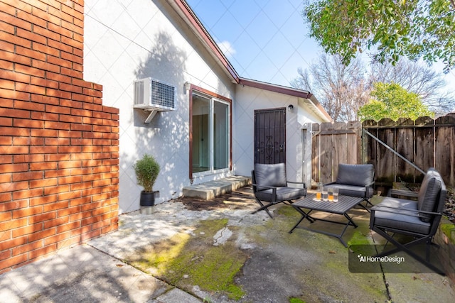 view of patio / terrace with a gate, a wall unit AC, and fence