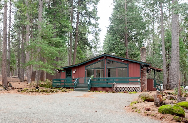 view of front facade with driveway and a chimney